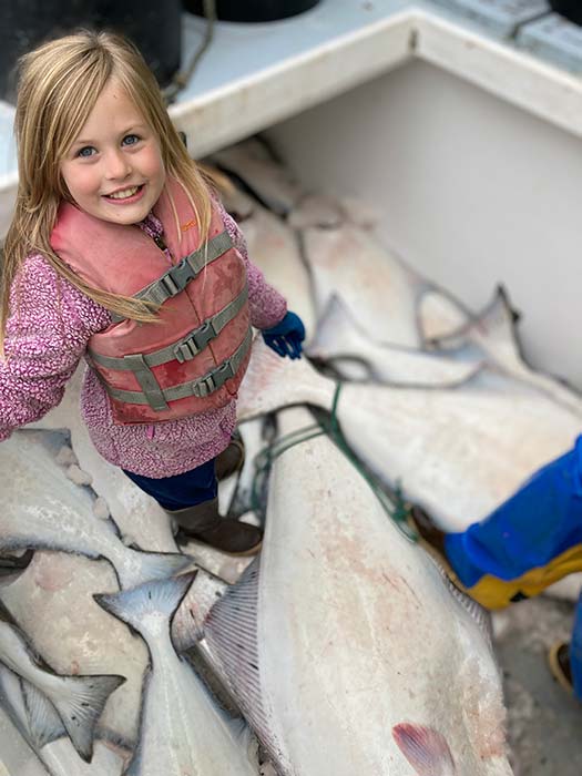 Family members catching halibut in Alaska